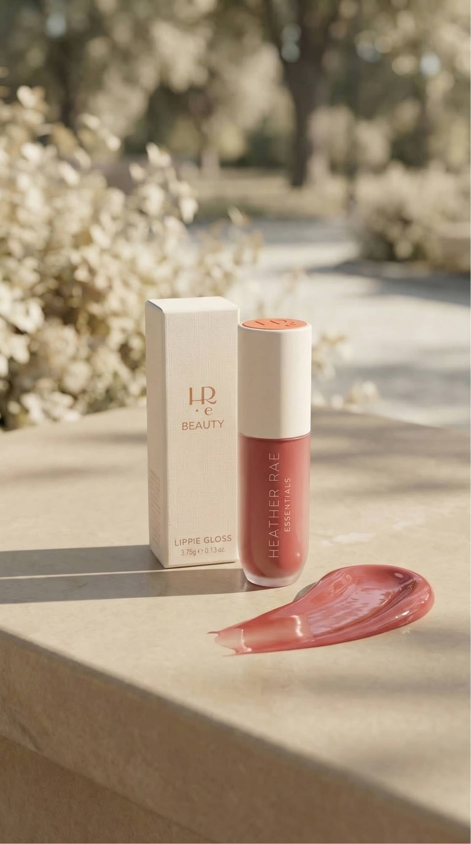 HRE Beauty still life with lip gloss tubes on wet travertine beside clear turquoise pool water