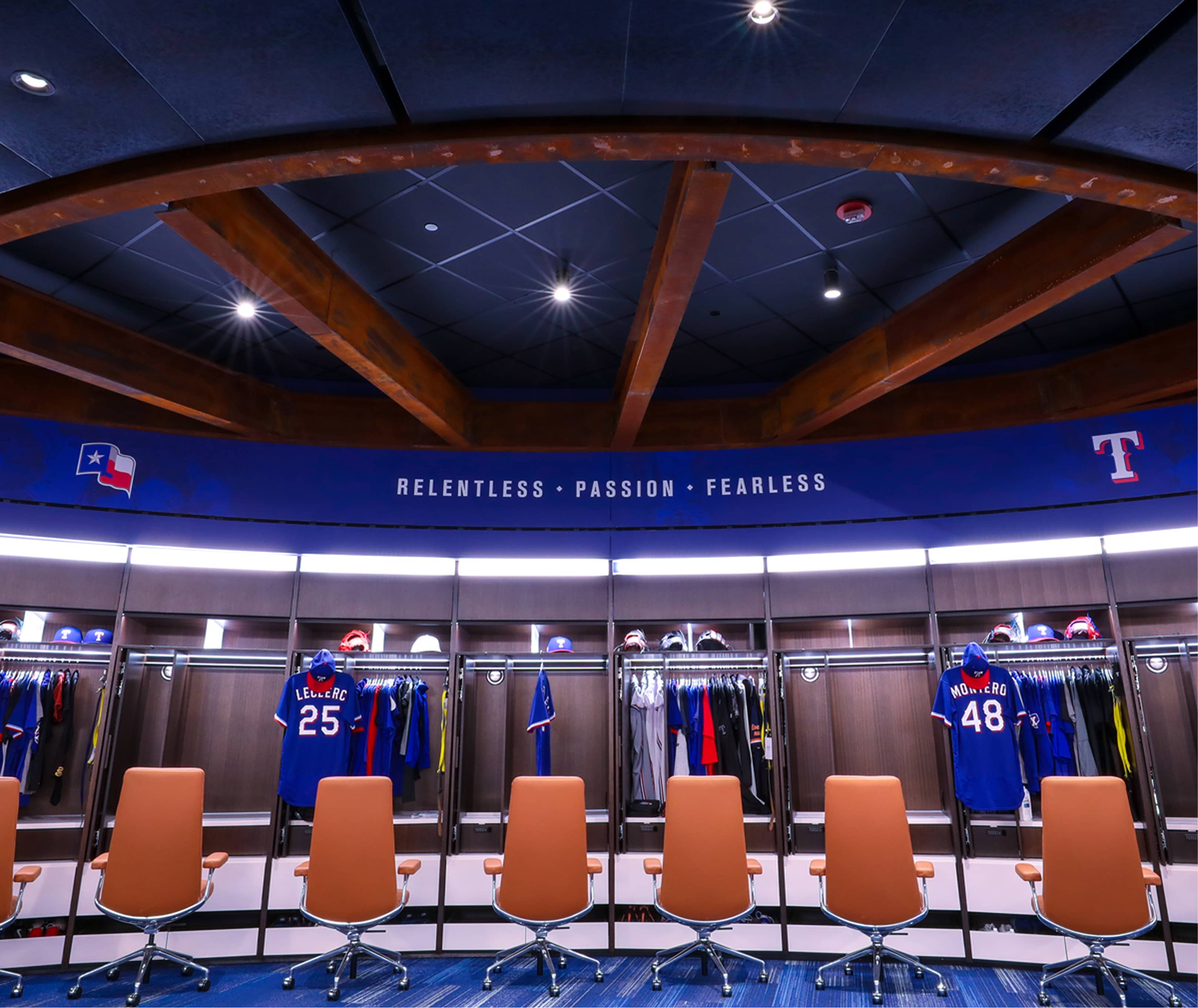 Player locker stalls under the curved blue fascia displaying Relentless Passion Fearless