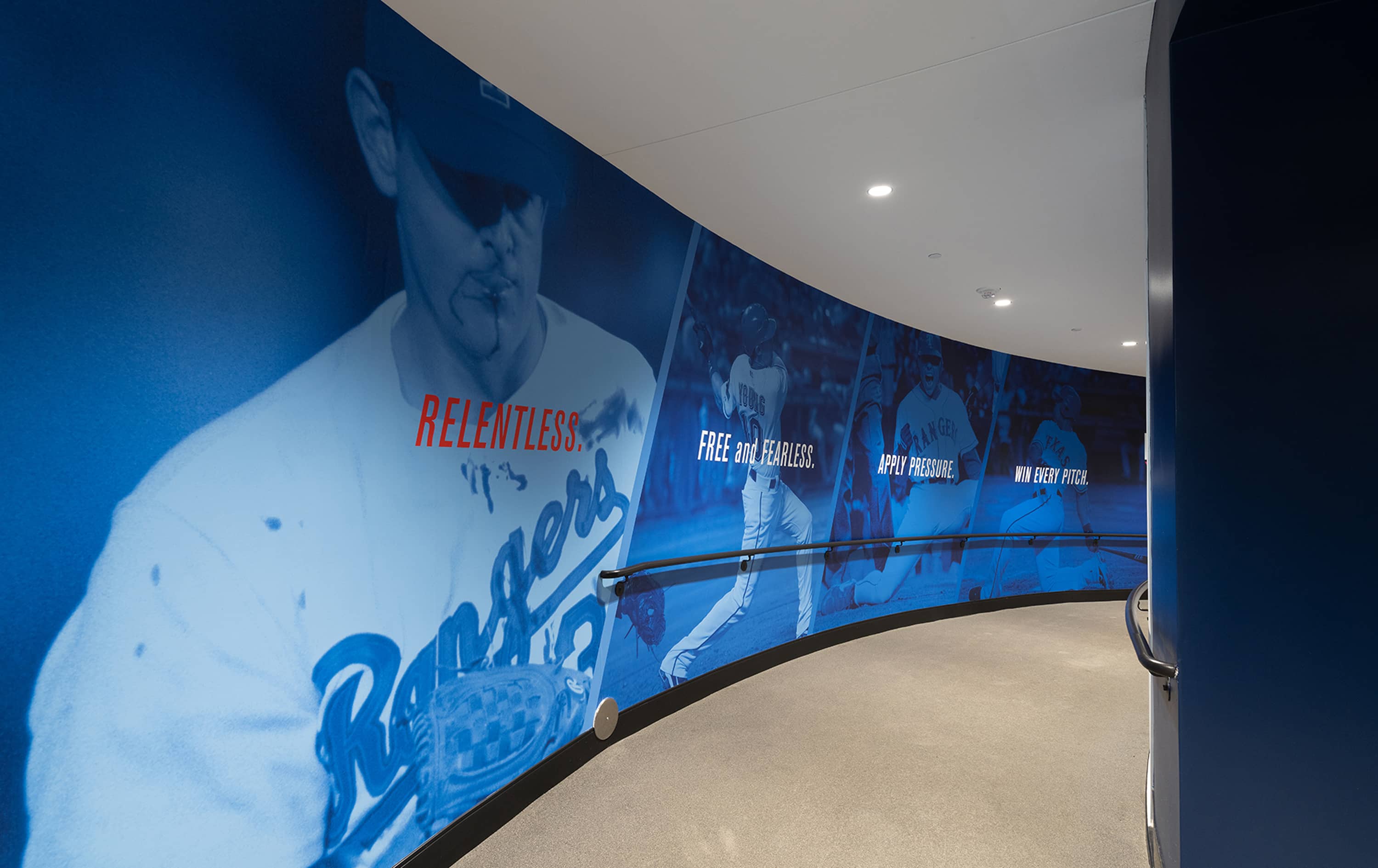 Curved player tunnel wall mural featuring bloodied Nolan Ryan on the mound with Relentless and Win Every Pitch