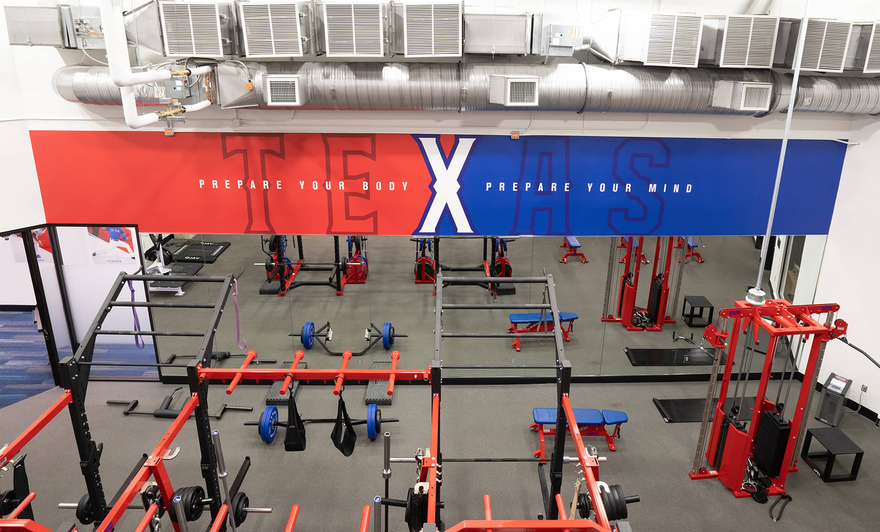 Mezzanine perspective of training floor and Prepare Your Body / Prepare Your Mind mirror graphic